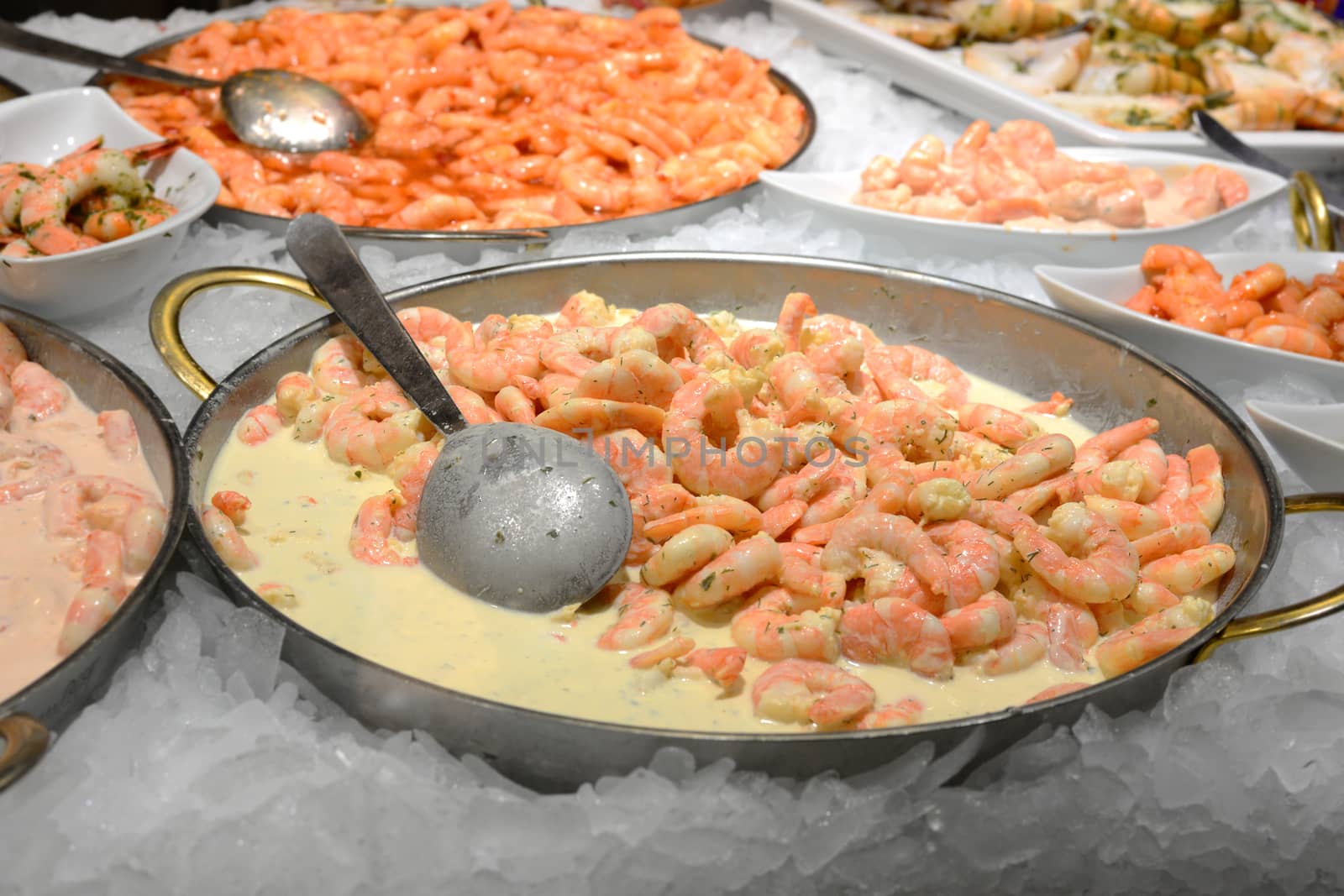 cooked peeled prawns in stainless steel plate on ice; street food in Salzburg, Austria