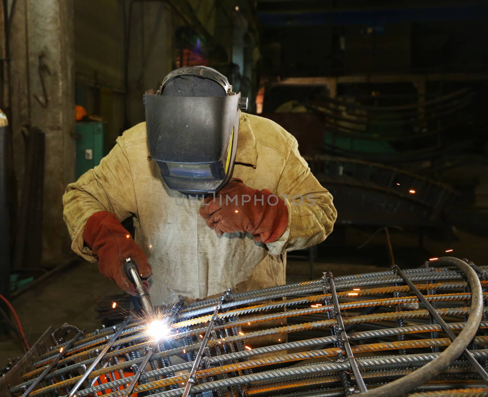 Welder in factory. Worker weld metal in factory and sparks