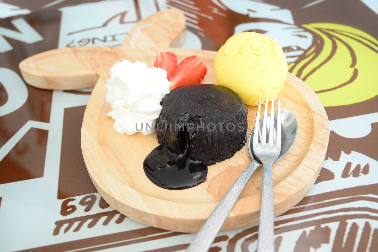 chocolate fondant with vanilla ice cream on wooden plate by gypsygraphy