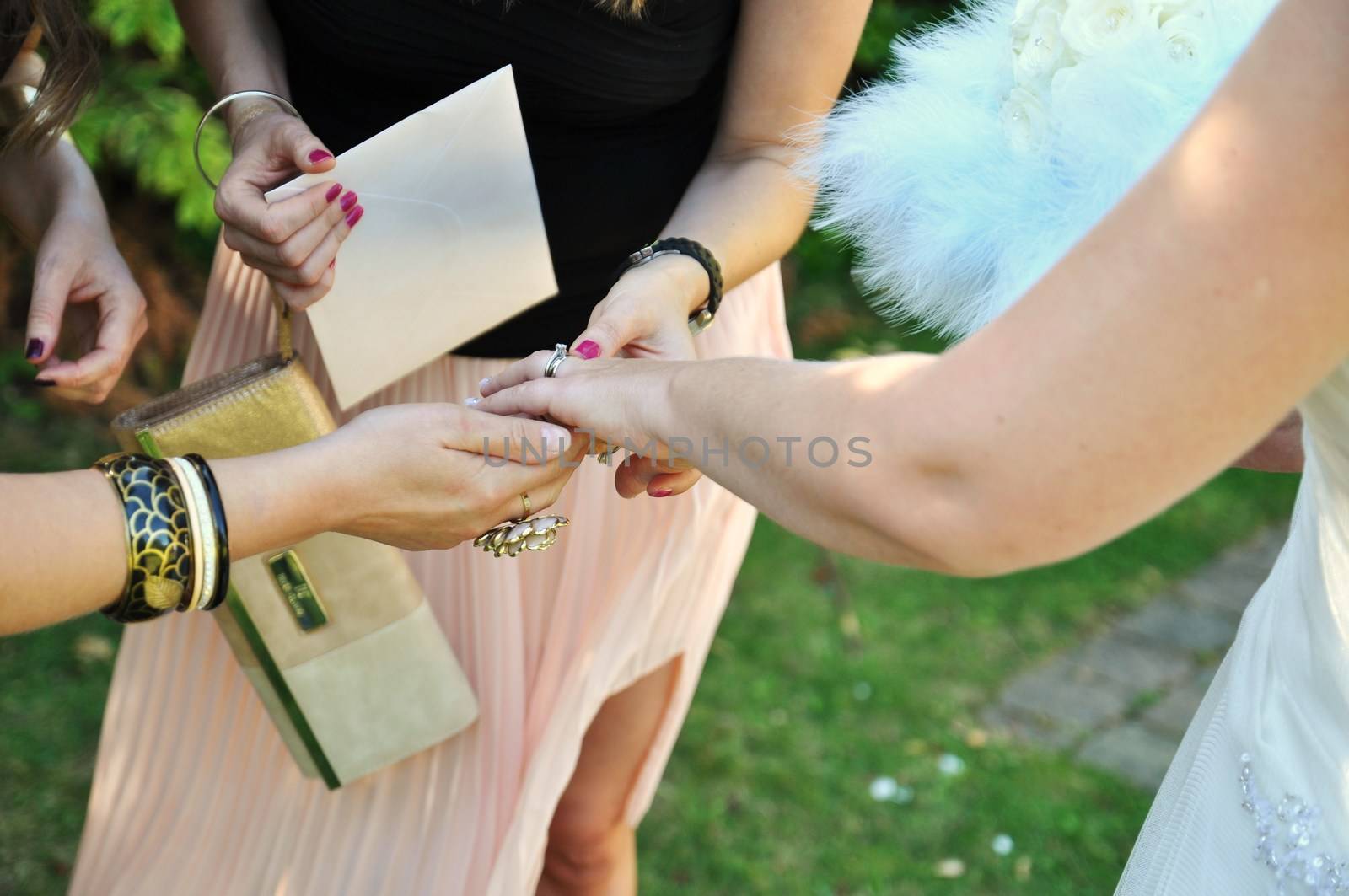 Bride shows her new wedding ring to female friends