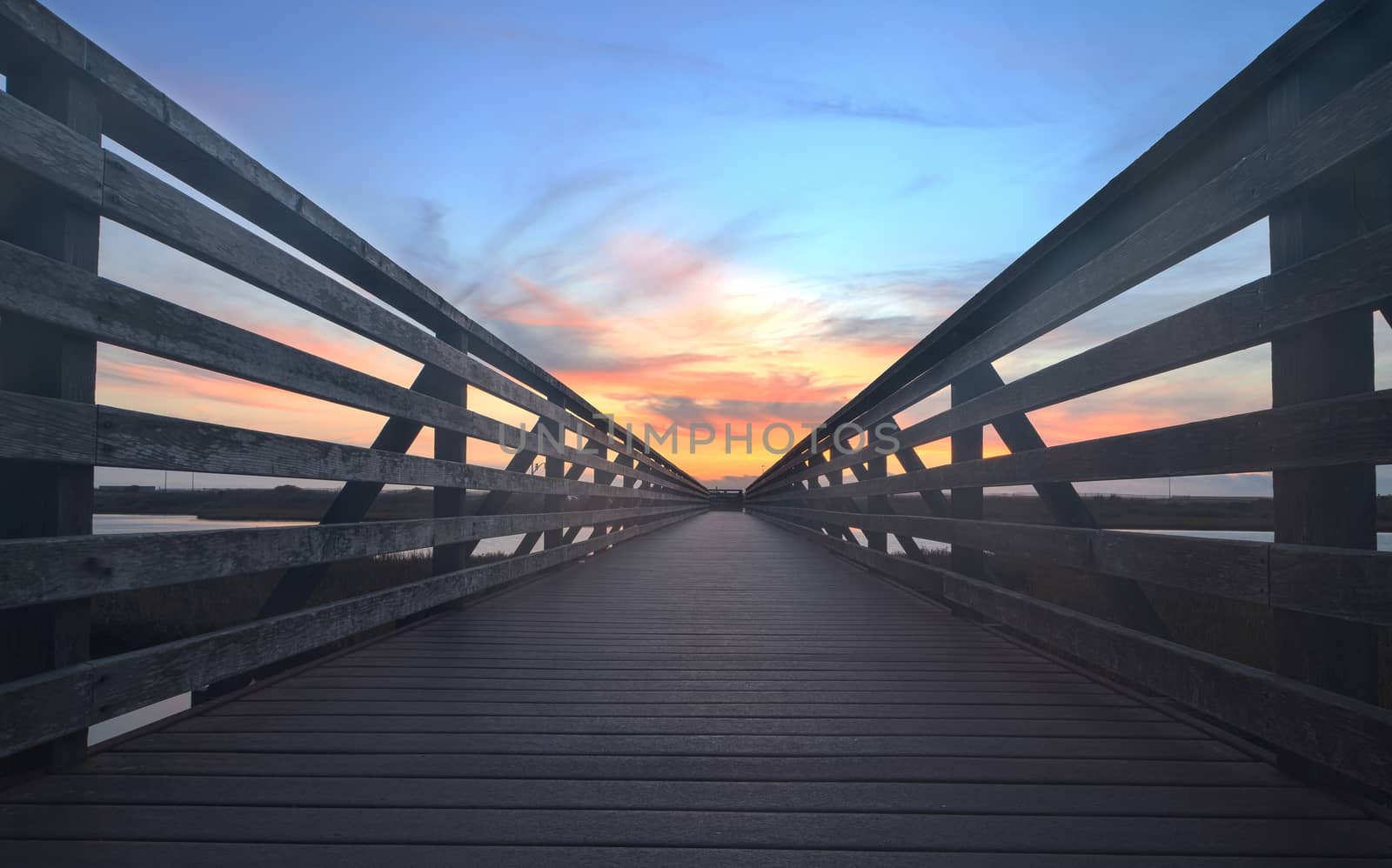 Wooden Boardwalk at sunset, to journey through Bolsa Chica Wetlands preserve in Huntington Beach, California, United States