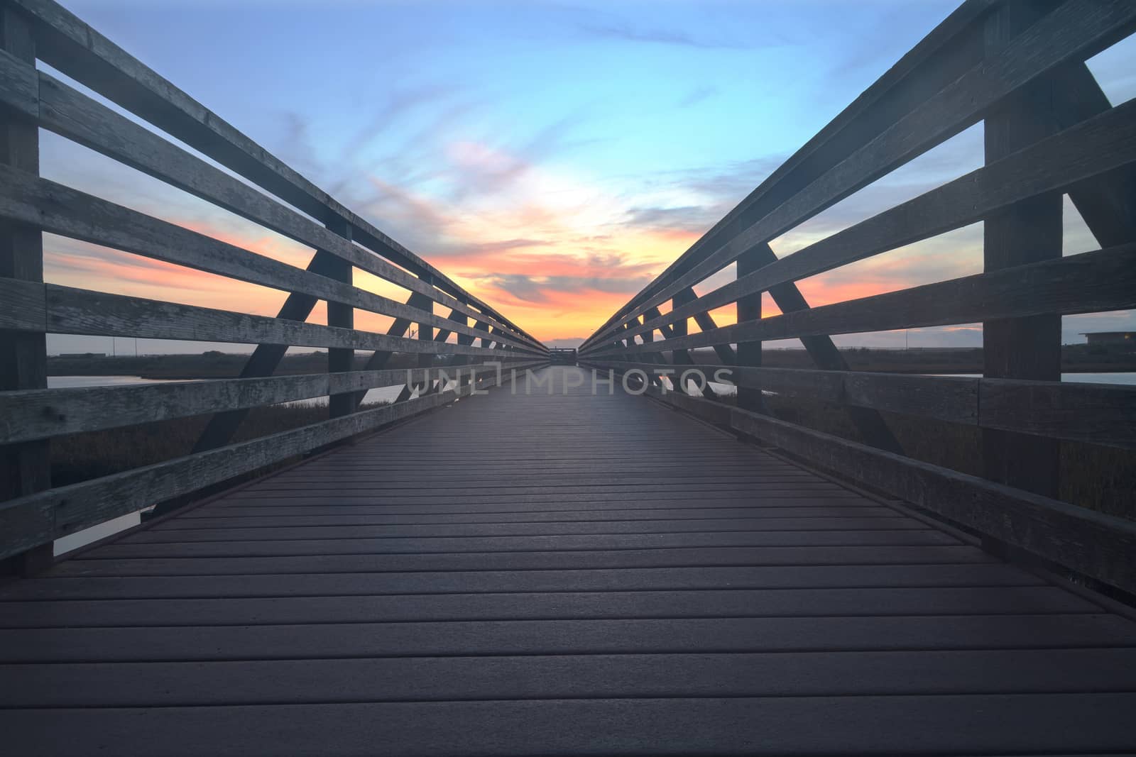 Wooden Boardwalk at sunset, to journey through Bolsa Chica Wetlands preserve in Huntington Beach, California, United States