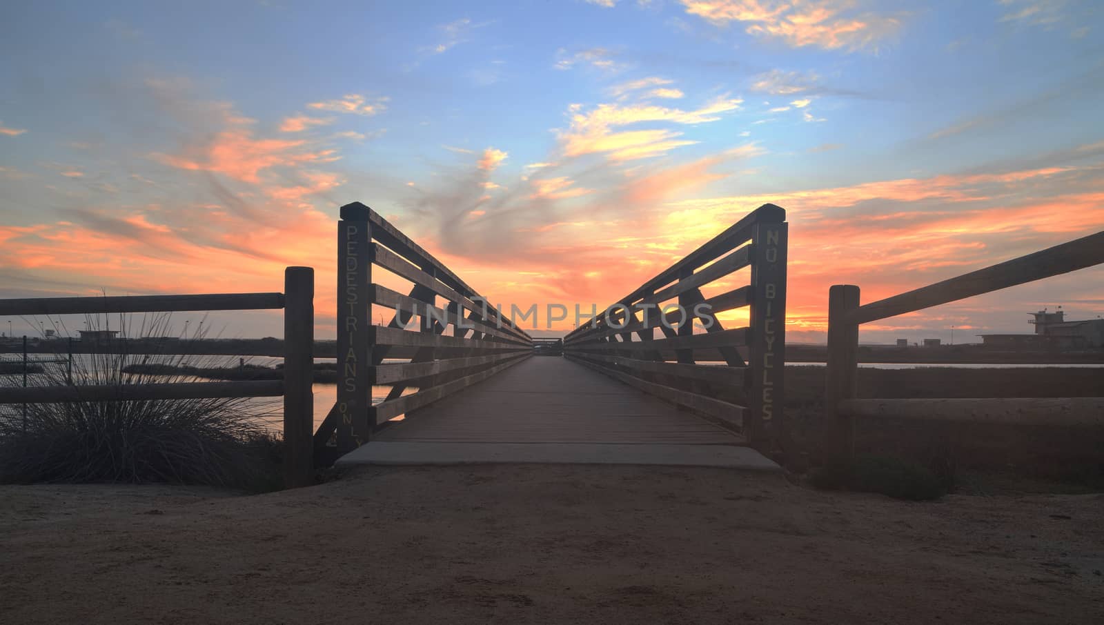 Wooden Boardwalk at sunset, to journey through Bolsa Chica Wetlands preserve in Huntington Beach, California, United States