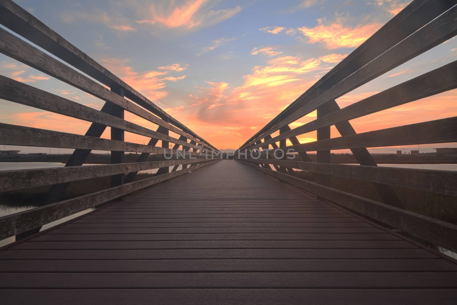 Wooden Boardwalk at sunset, to journey through Bolsa Chica Wetlands preserve in Huntington Beach, California, United States