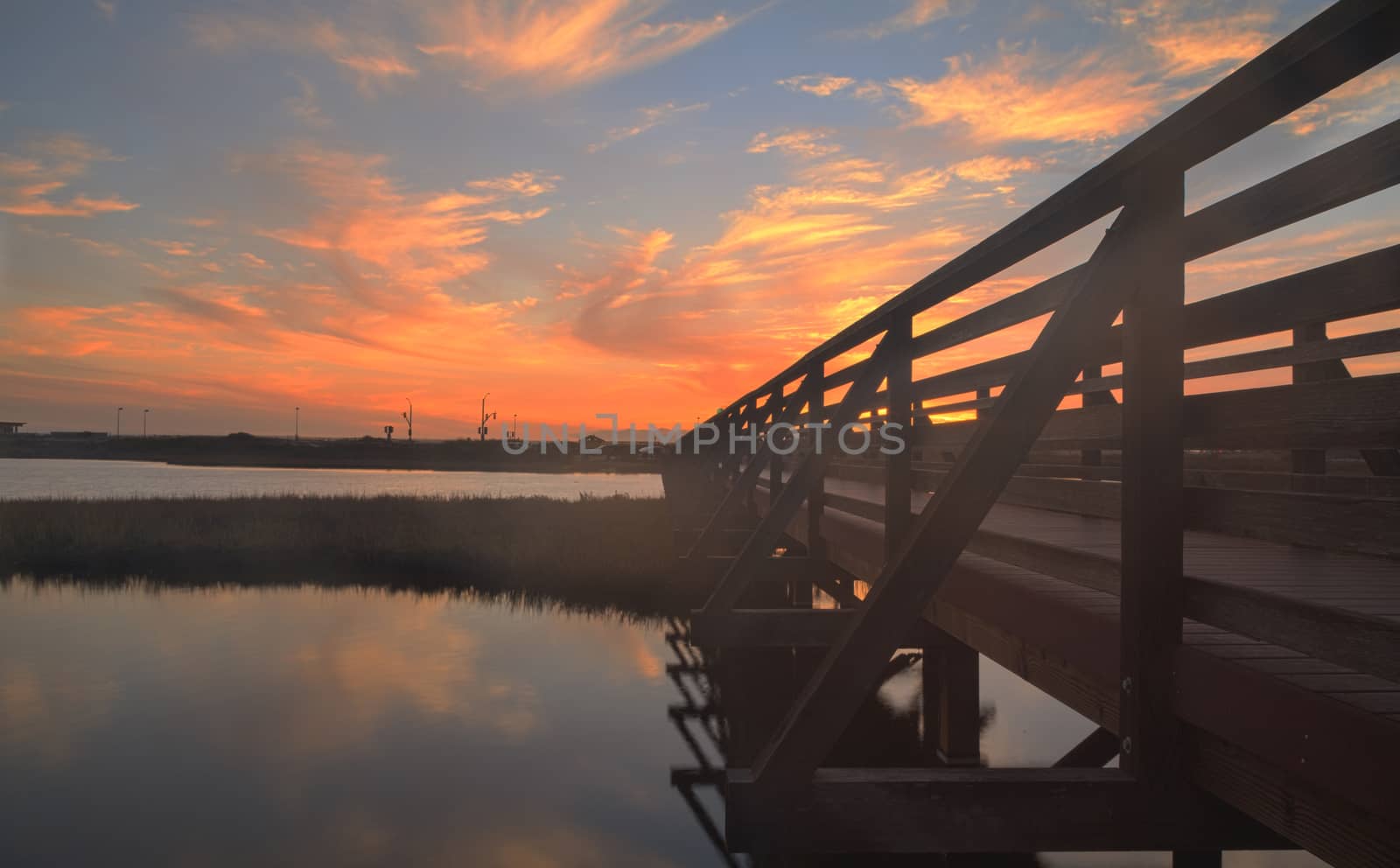 Wooden Boardwalk at sunset, to journey through Bolsa Chica Wetlands preserve in Huntington Beach, California, United States