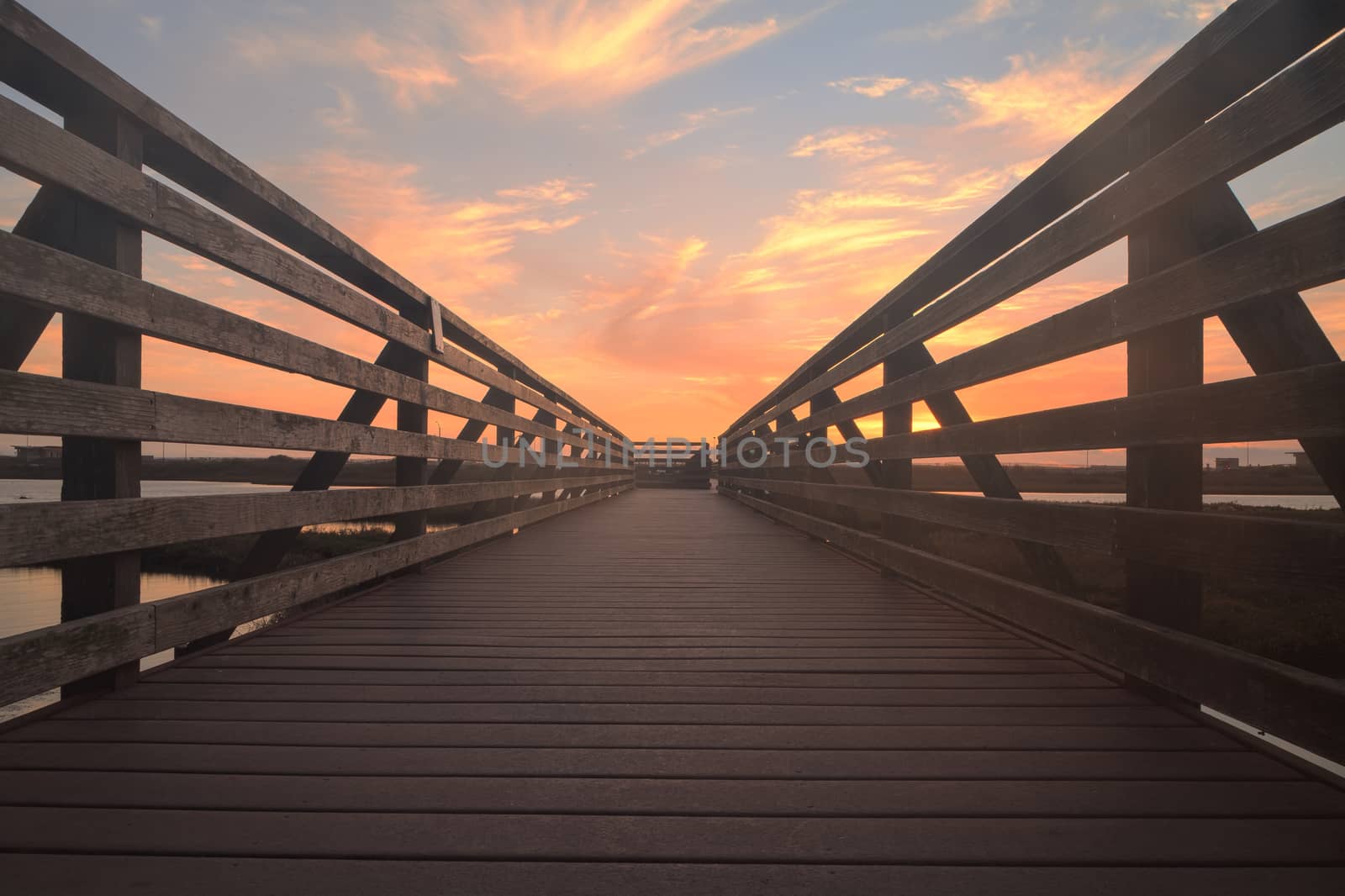 Wooden Boardwalk at sunset, to journey through Bolsa Chica Wetlands preserve in Huntington Beach, California, United States