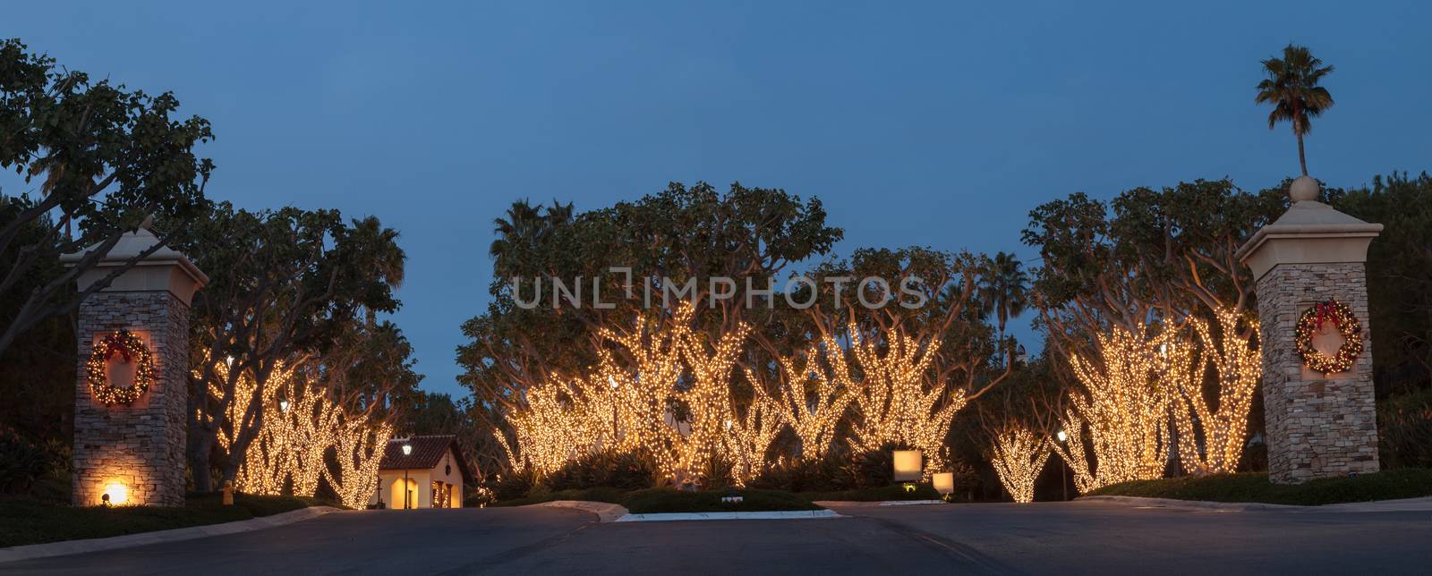 Crystal Cove, California — December 25, 2014: White Christmas holiday lights in Crystal Cove on the edge of Laguna Beach and Newport Beach on trees with a wreath on each pillar.