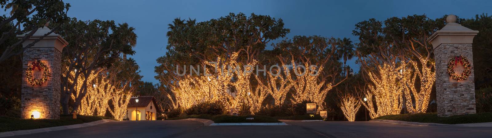 Crystal Cove, California — December 25, 2014: White Christmas holiday lights in Crystal Cove on the edge of Laguna Beach and Newport Beach on trees with a wreath on each pillar.