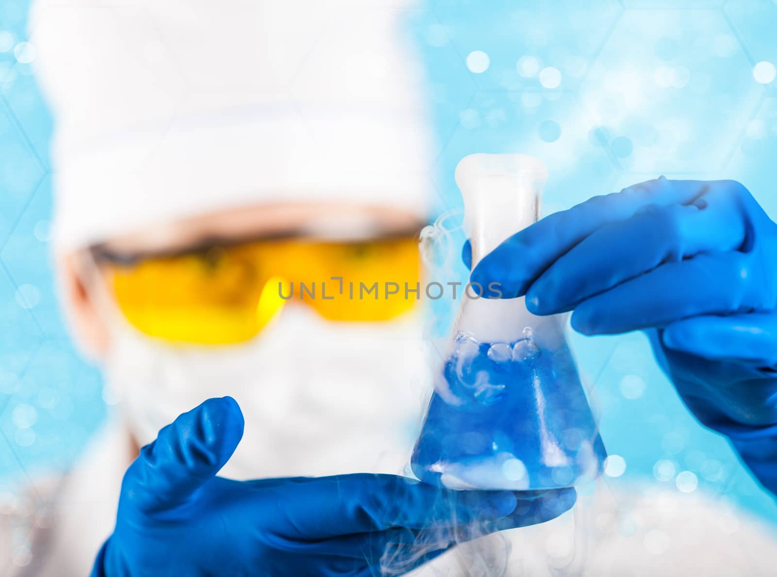 Woman chemist examines test tube on a blue background