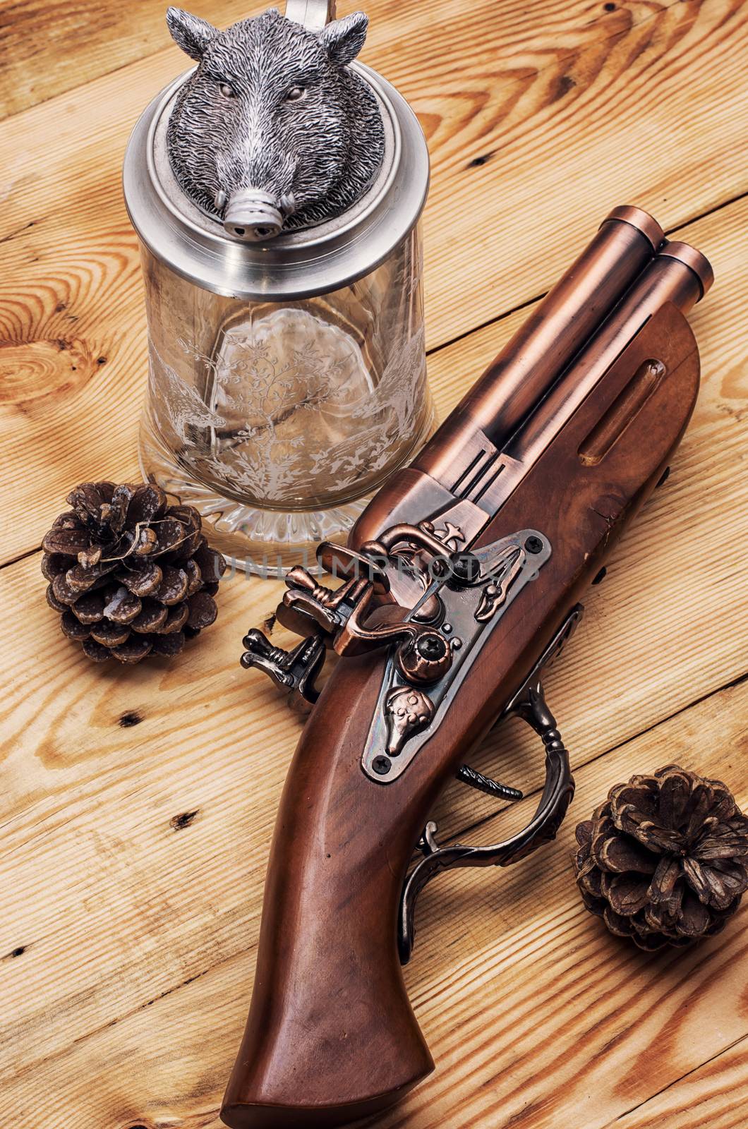 Old hunting musket on a light wooden background with forest cones