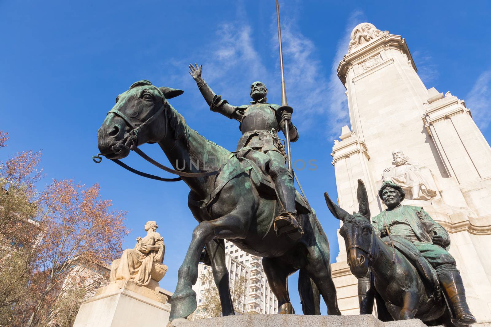 Stone statue of Miguel de Cervantes and bronze sculptures of Don Quixote and Sancho Panza on the Square of Spain (Plaza de Espana) in Madrid.