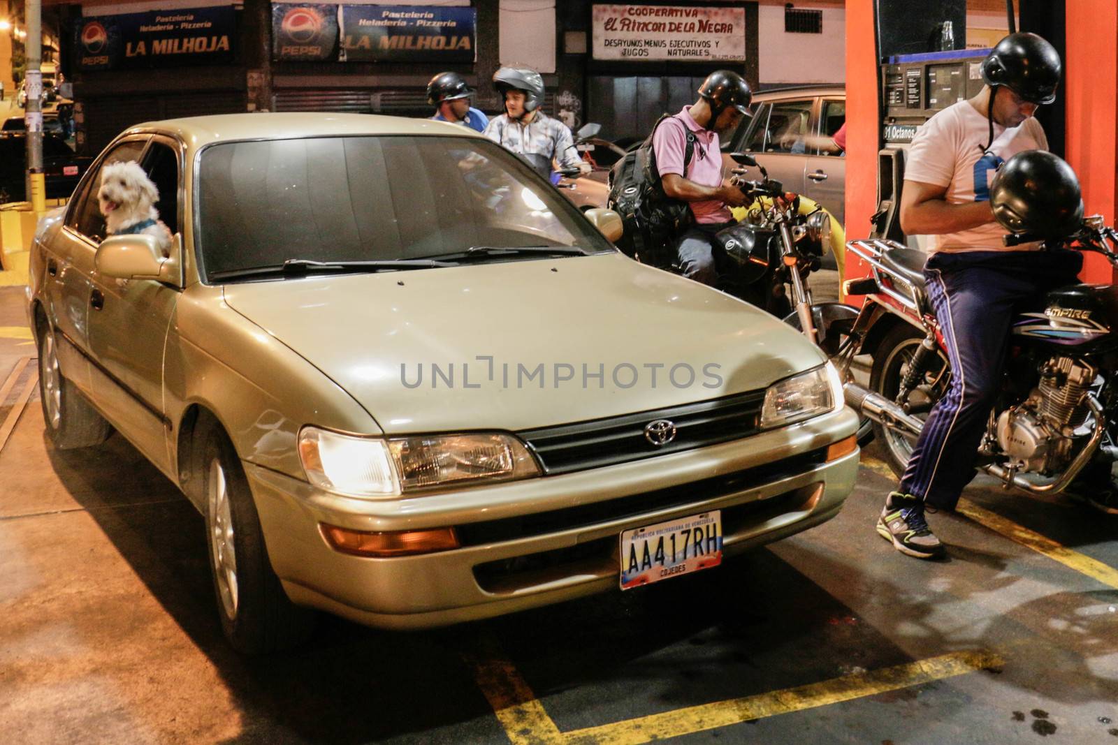 VENEZUELA, Caracas: Motorcyclists queue at a gas station in Caracas, on February 17, 2016. Venezuela's President Nicolas Maduro said Wednesday he would raise the price of gasoline for the first time in 20 years, as he faces growing pressure to ease an economic crisis. Maduro said in a televised address he would raise the pump price of premium gasoline from its current super-low level of $0.01 to the equivalent of $0.95 at the fixed official exchange rate, in a country where citizens are struggling with soaring inflation.