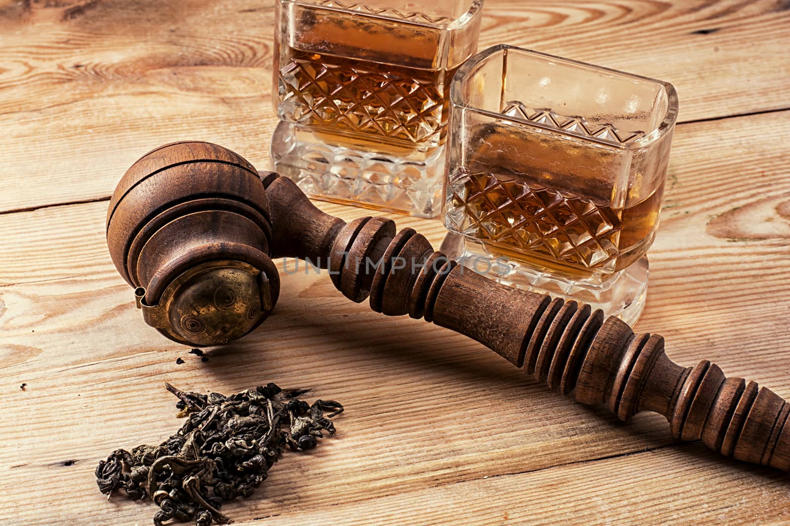 Smoking pipe in a retro style,dark chocolate and glasses of whiskey on wooden background