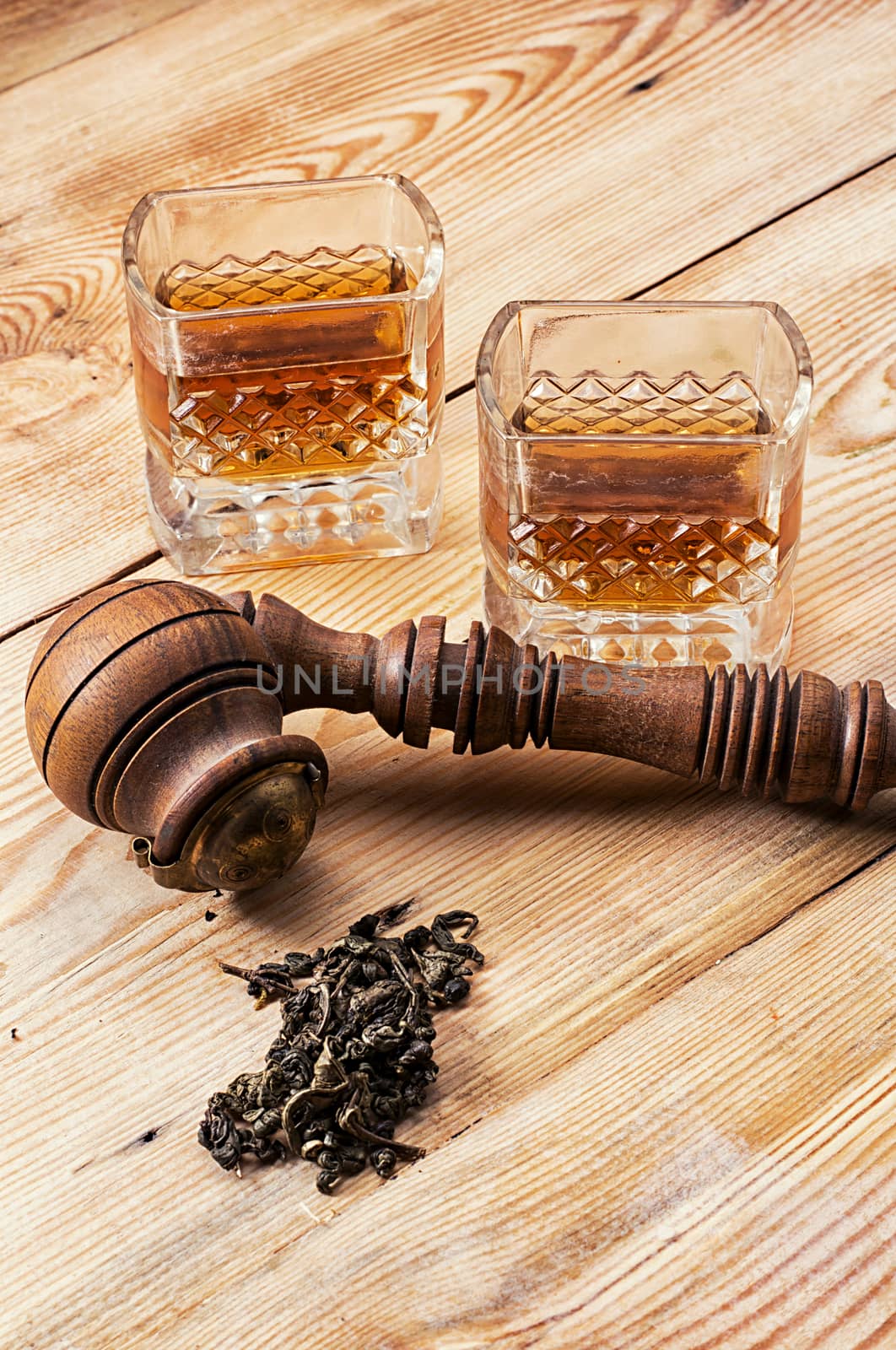 Smoking pipe in a retro style,dark chocolate and glasses of whiskey on wooden background