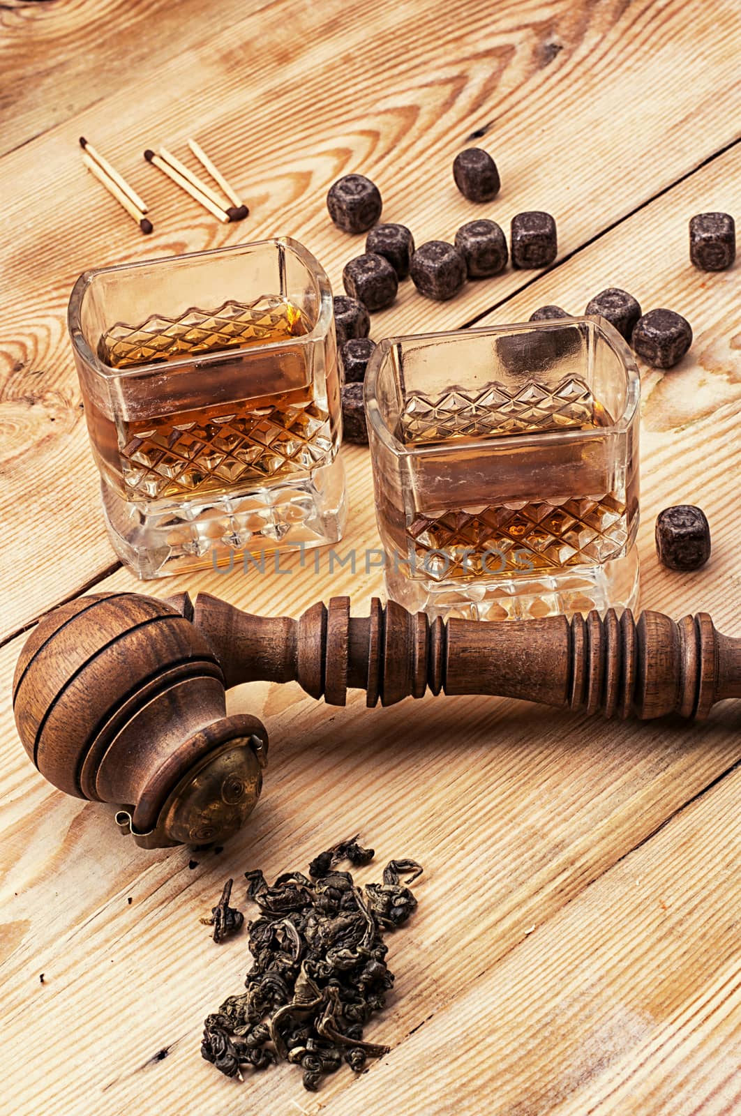 Smoking pipe in a retro style,dark chocolate and glasses of whiskey on wooden background