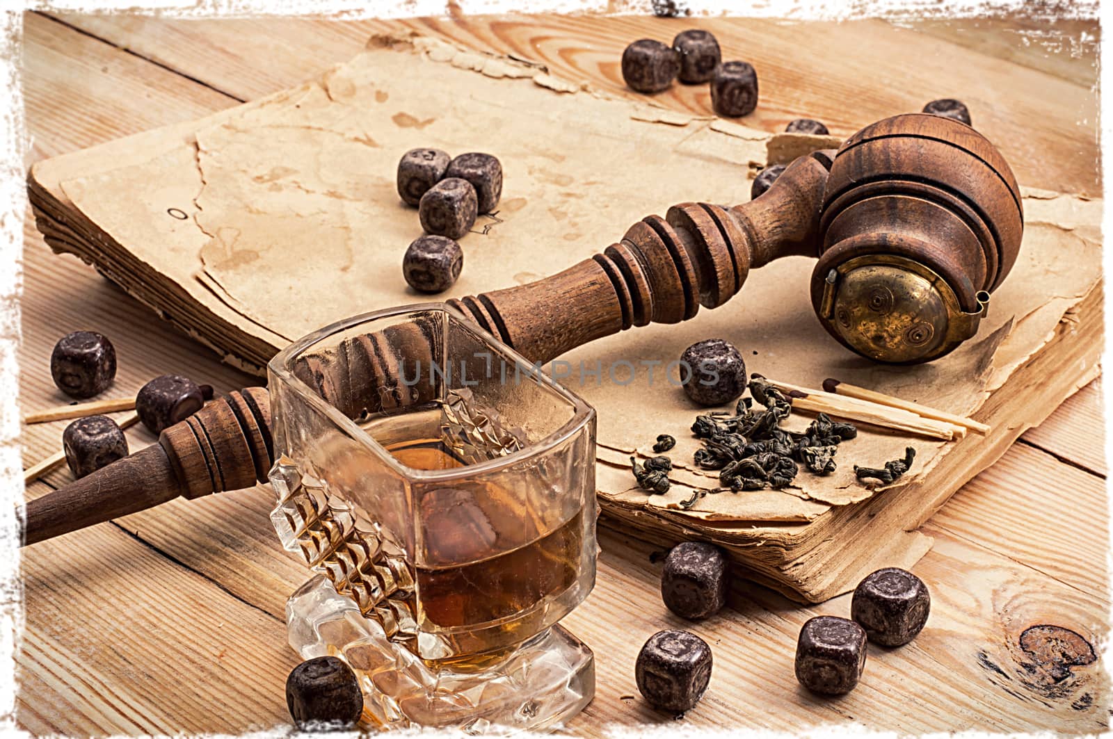 Smoking pipe in a retro style,dark chocolate and glasses of whiskey on wooden background