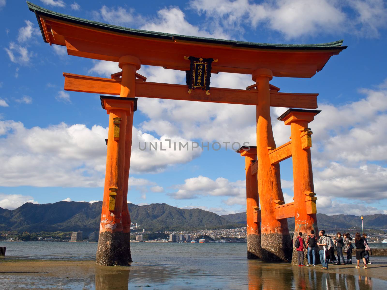 MIYAJIMA HIROSHIMA, JAPAN NOVEMBER 10, 2015: The famous orange floating shinto gate (Torii) of Itsukushima shrine panorama, Miyajima island of Hiroshima prefecture, Japan during low tide.