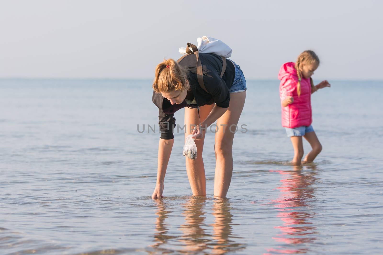 A young girl and a child of six shells collected in the sea early in the morning