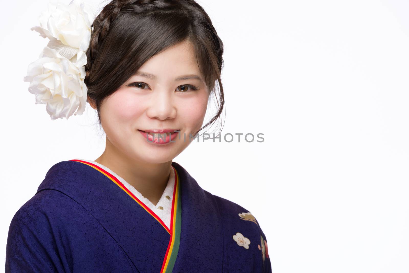 A portrait of a beautiful young Japanese girl in a blue kimono for her coming of age ceremony on her 20th birthday.