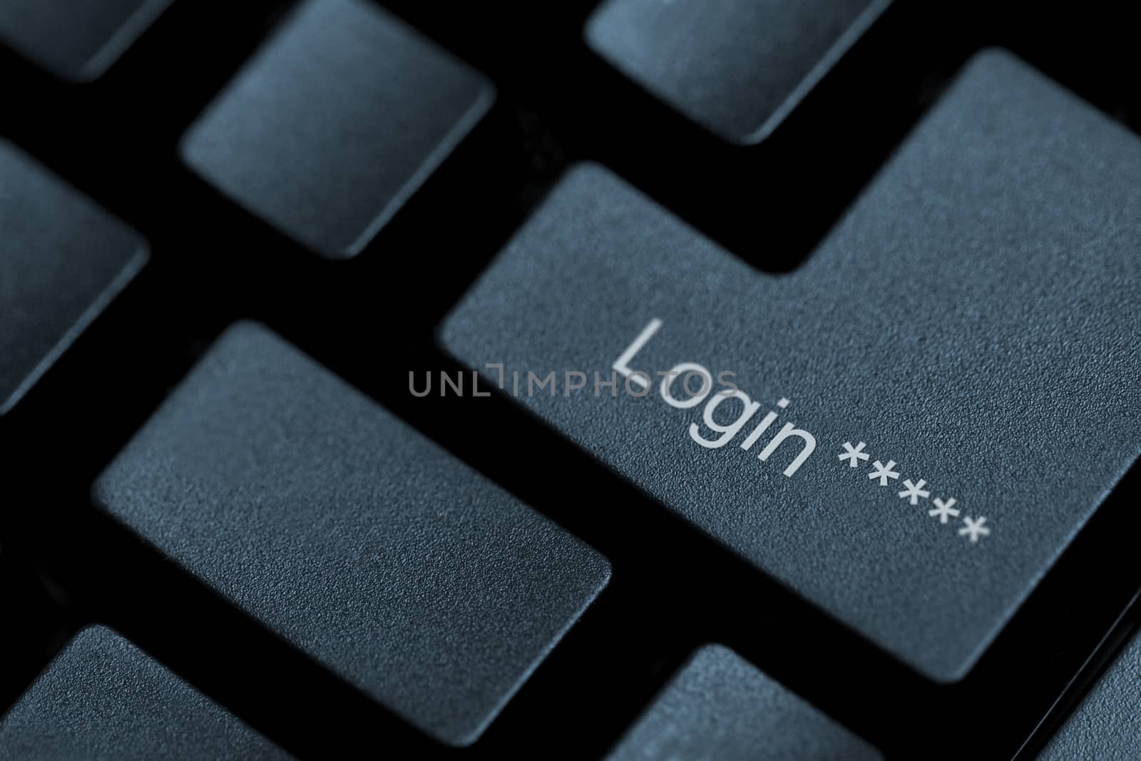Horizontal close up of black keys on a keyboard with the word login on one of them
