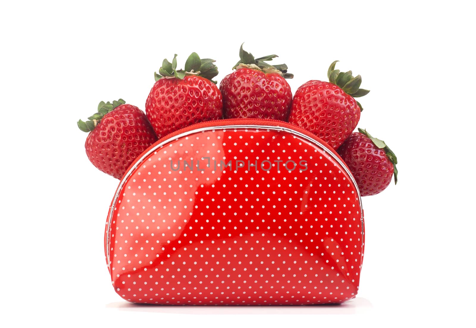 Five fresh strawberries in a plastic dotted red purse