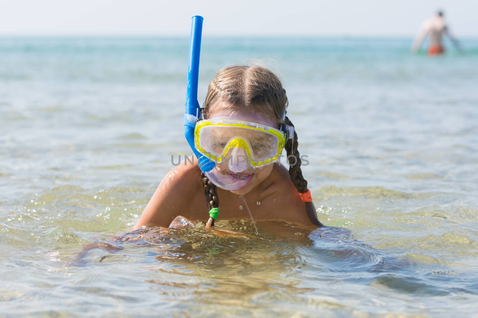 Six-year girl swims with a mask and snorkel under water at the seaside