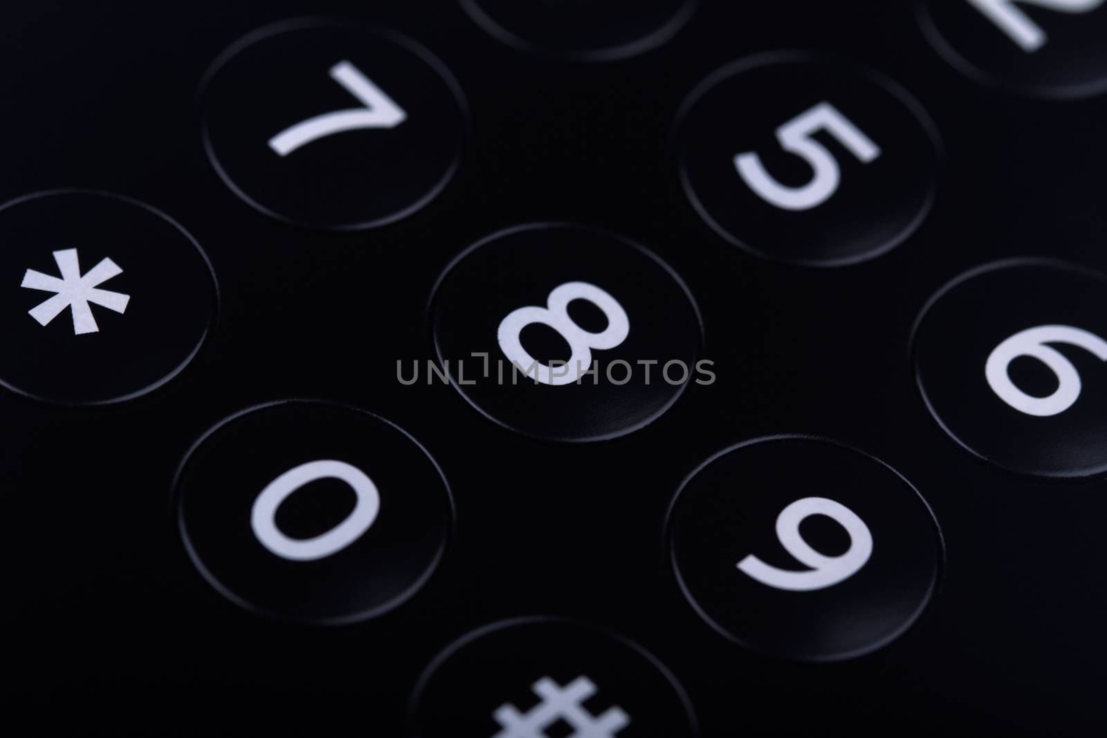 Horizontal top view close up of the keypad of a telephone with numbers showing