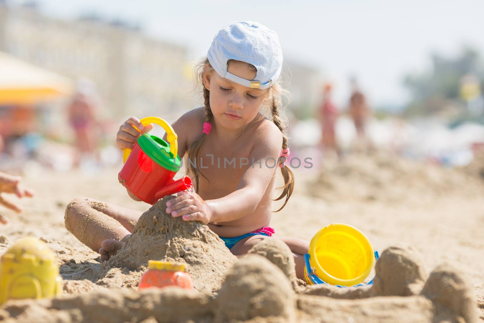 Four-year girl playing in the sand on the beach seaside