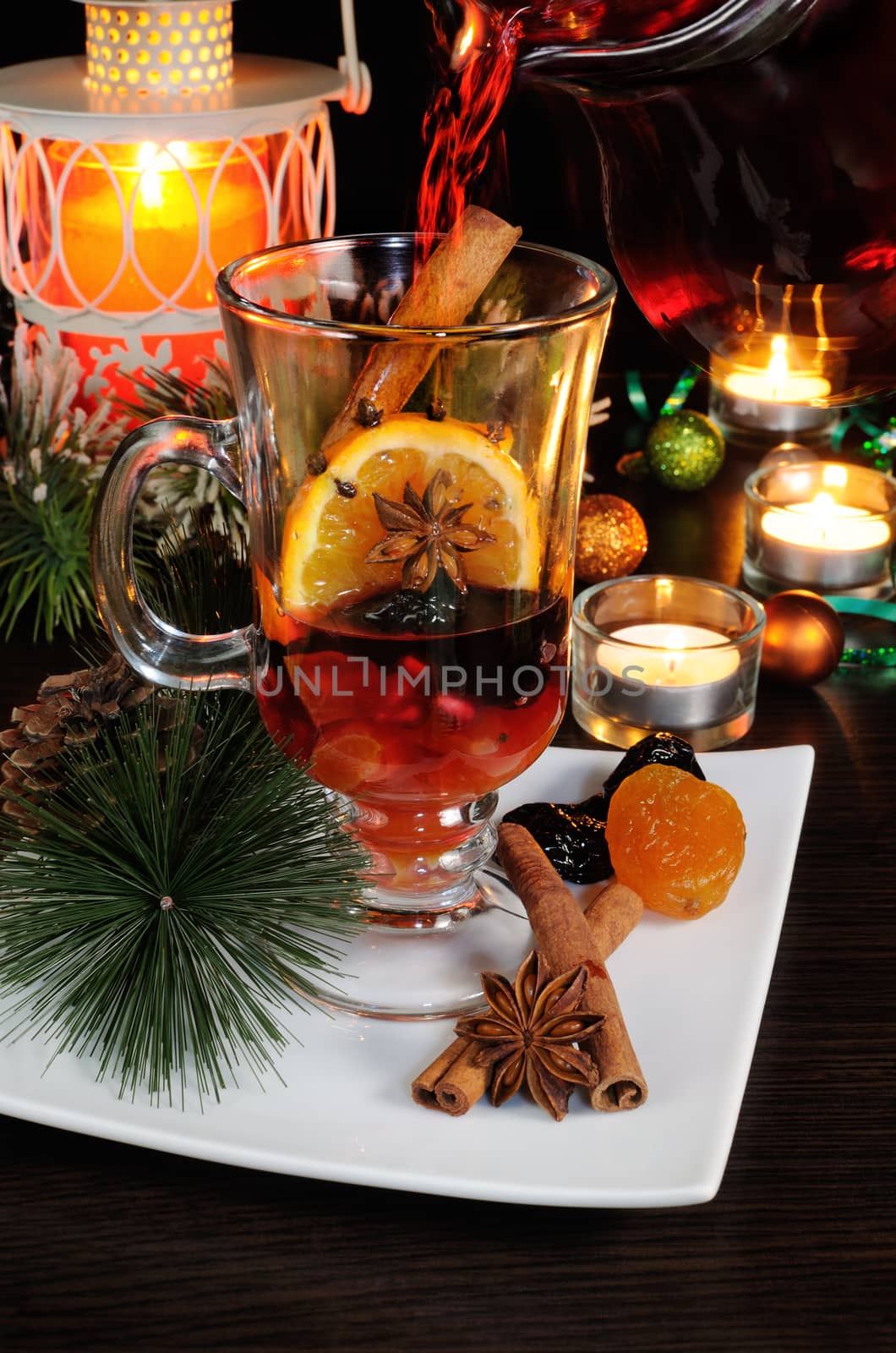 filling a glass of mulled wine with ingredients on Christmas