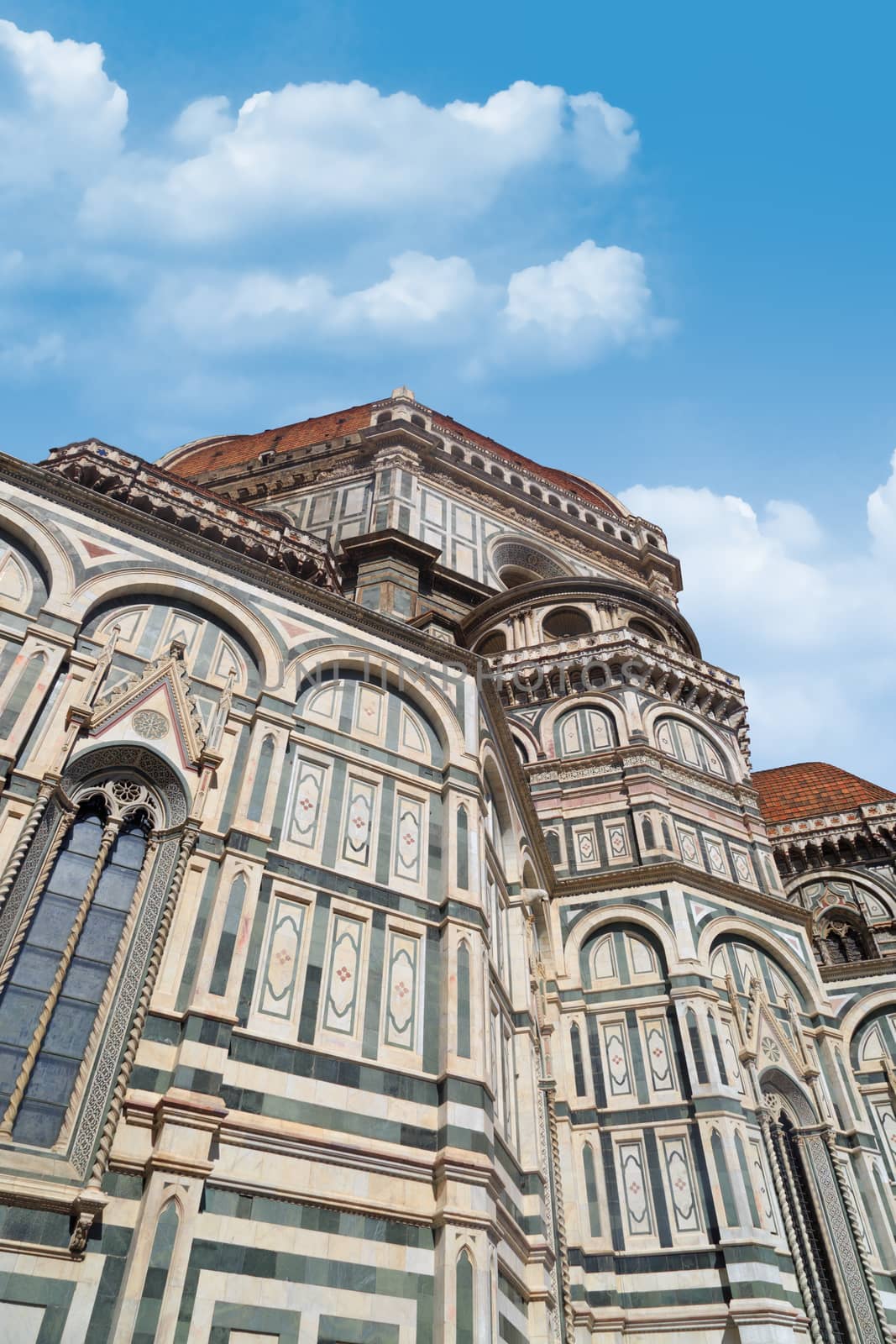 Bottom view of famous historical Florence Duomo, Santa Maria Del Fiore, on cloudy blue sky background.