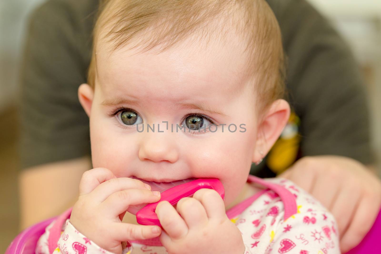Happy cute little one year old girl indoor with toy in white pink dress