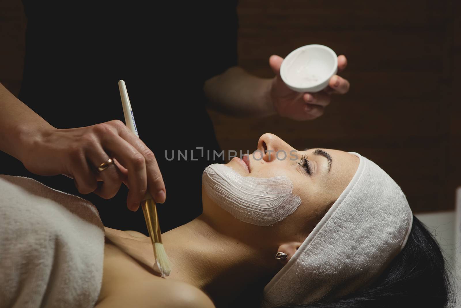 Close-up of young woman with facial mask by sarymsakov