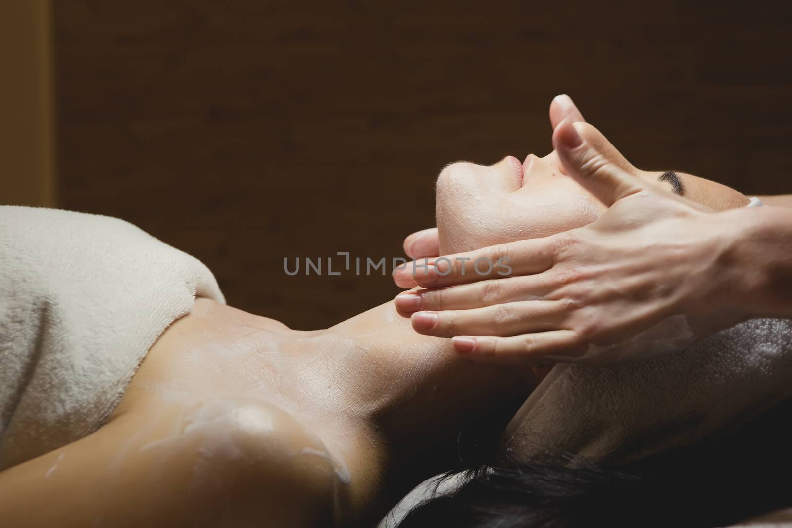 Close-up of young woman with facial mask in spa