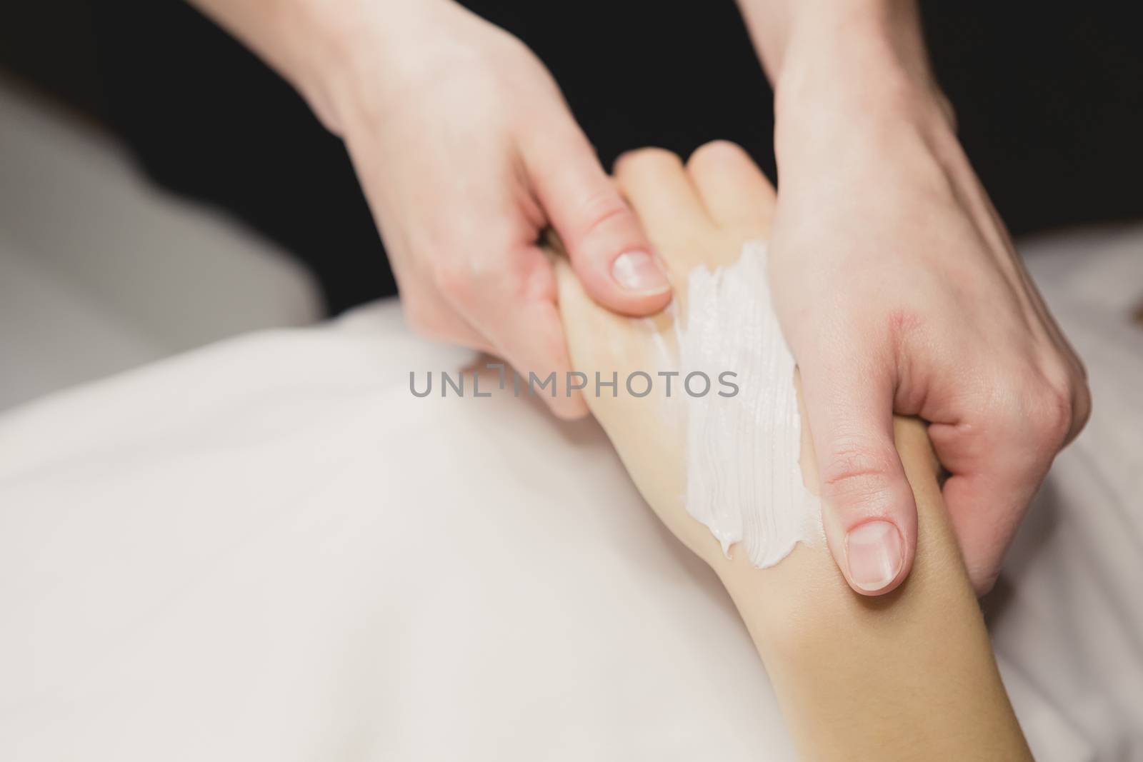 Close up of hands applying cream over table. SPA