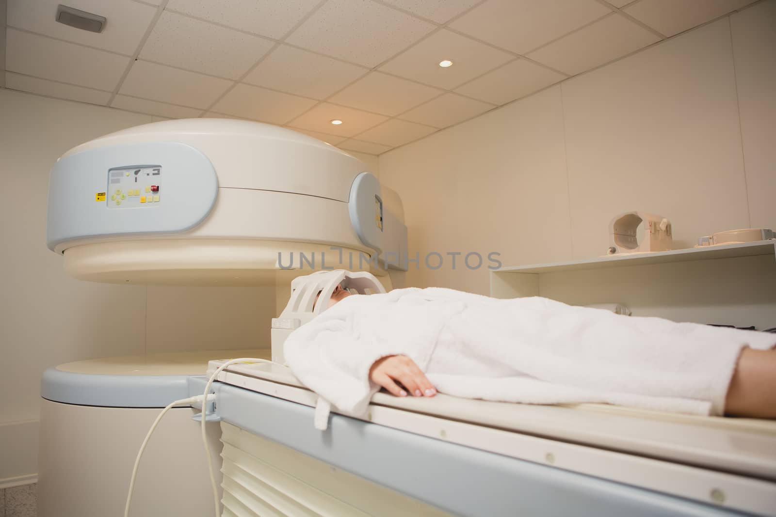 Patient being scanned and diagnosed on a computed tomography scanner in a hospital. Modern medical equipment, medicine and health care concept.