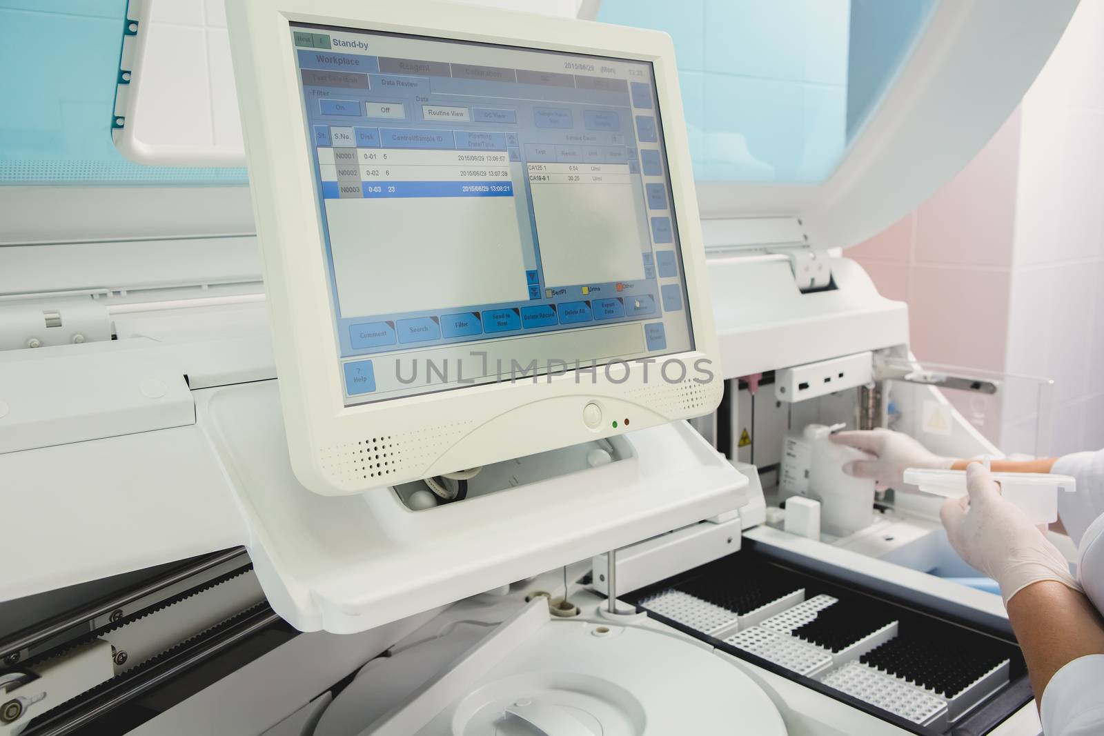 Lab tech loading samples into a chemistry analyzer in clinic