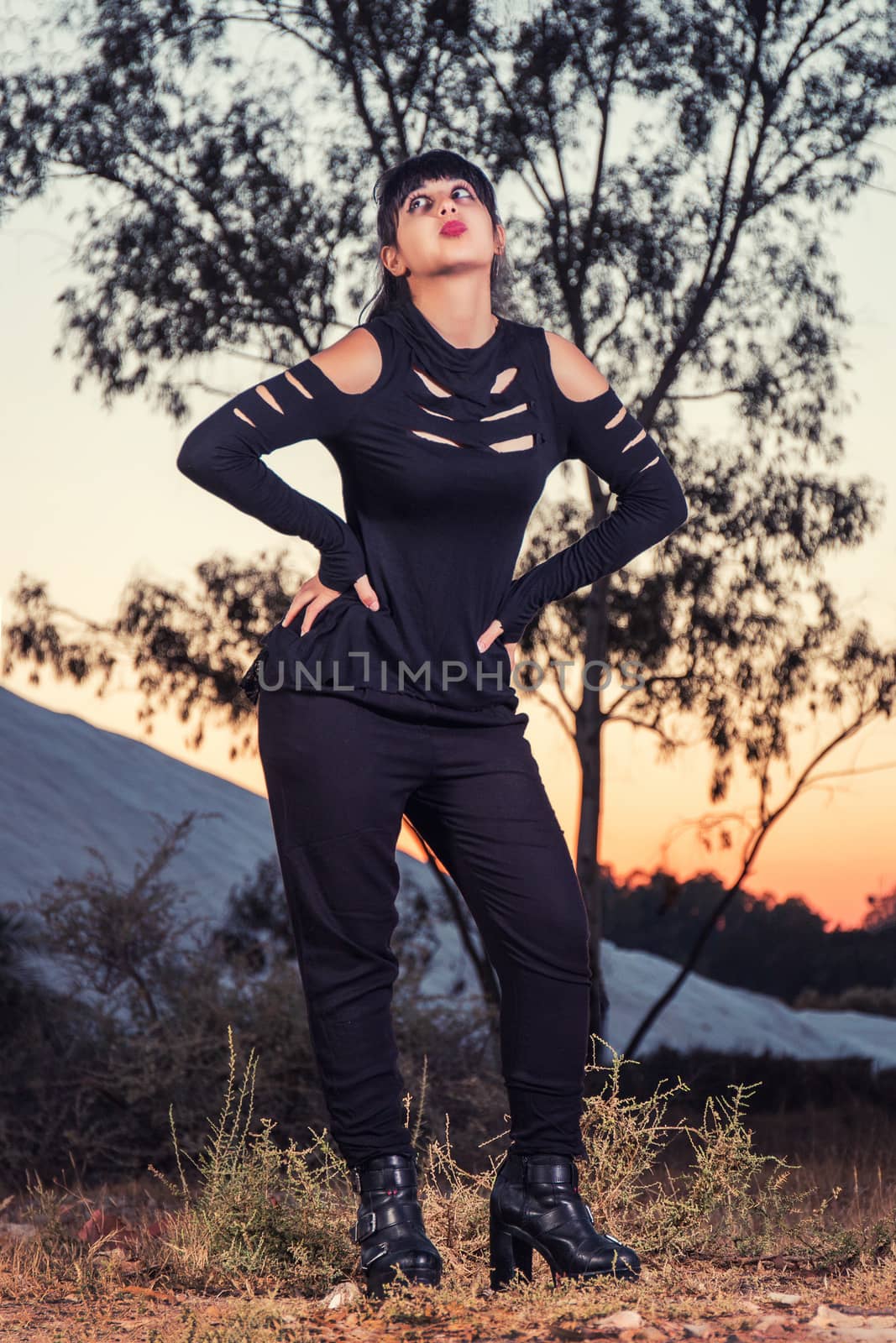 View of a beautiful young girl in gothic clothing on the nature.