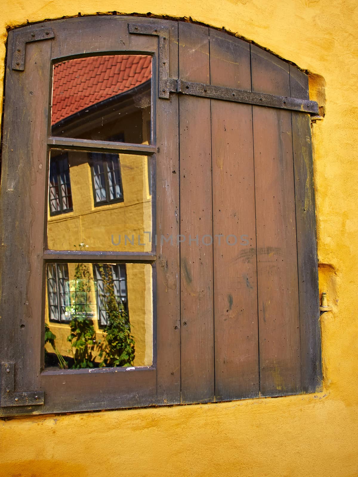 Rustic window with wooden exterior shutters by Ronyzmbow