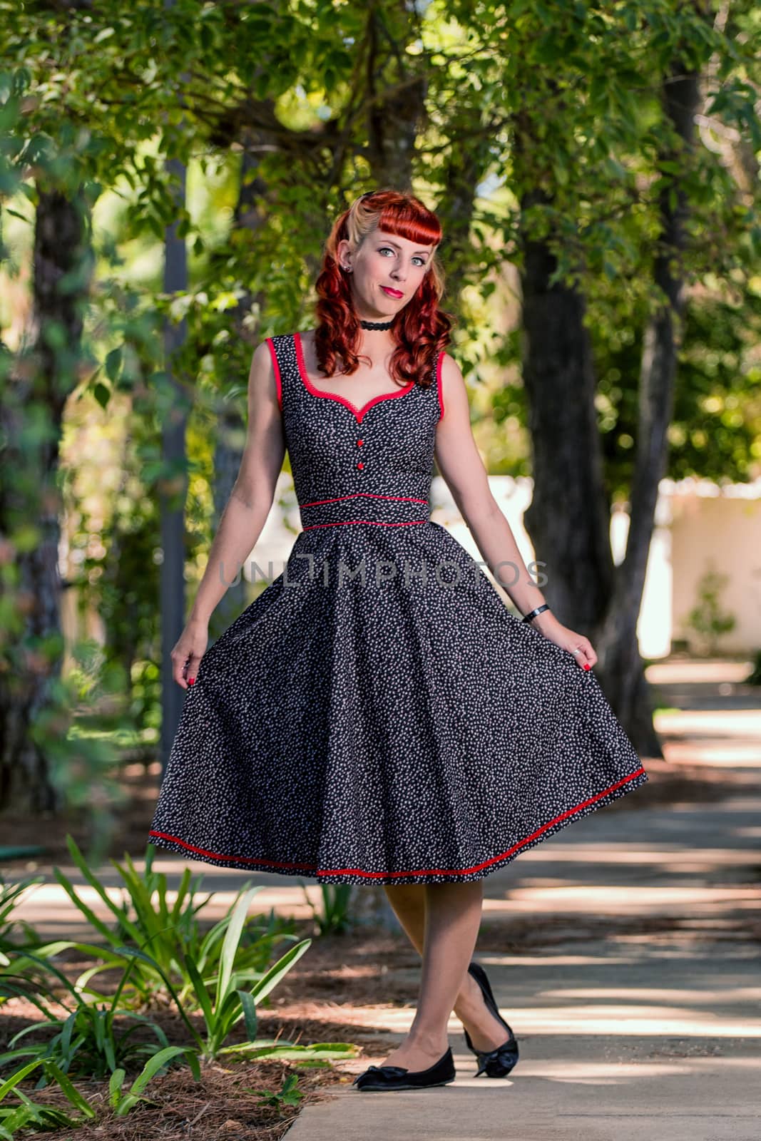 View of a young woman with a simple spring dress posing on the park.