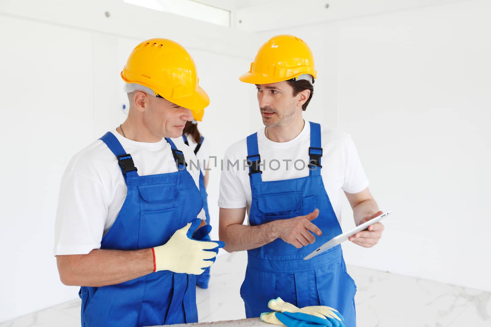 Team of builders with construction plan indoors