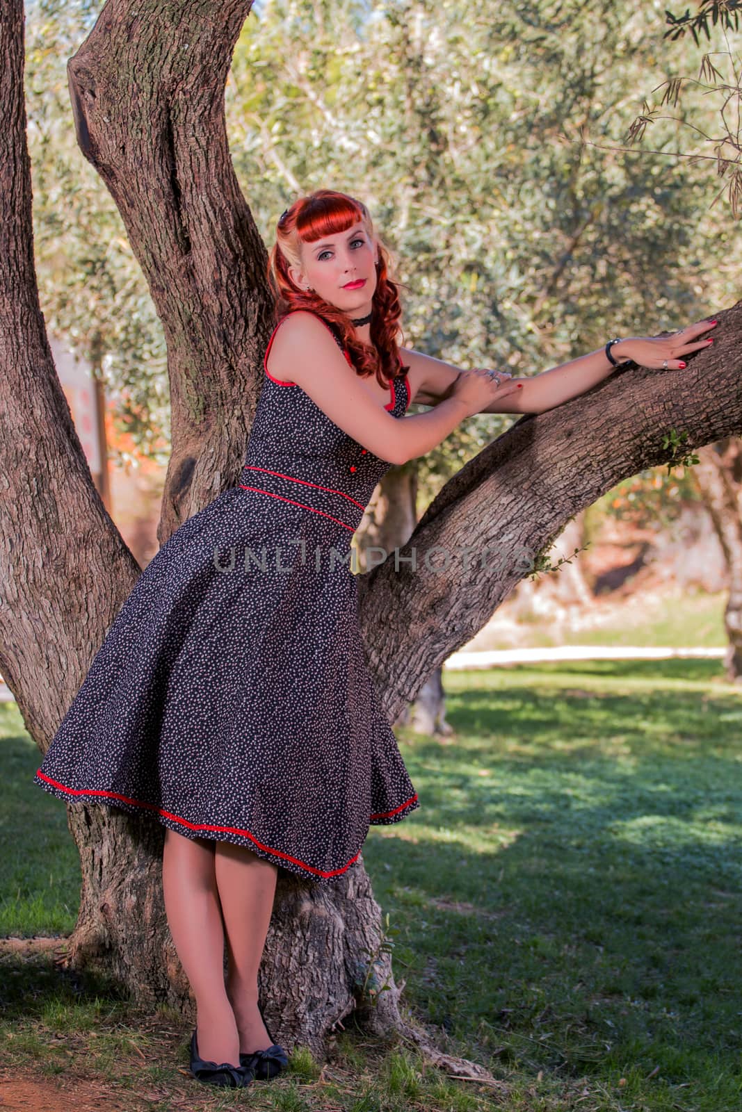 View of a young woman with a simple spring dress posing on the park.