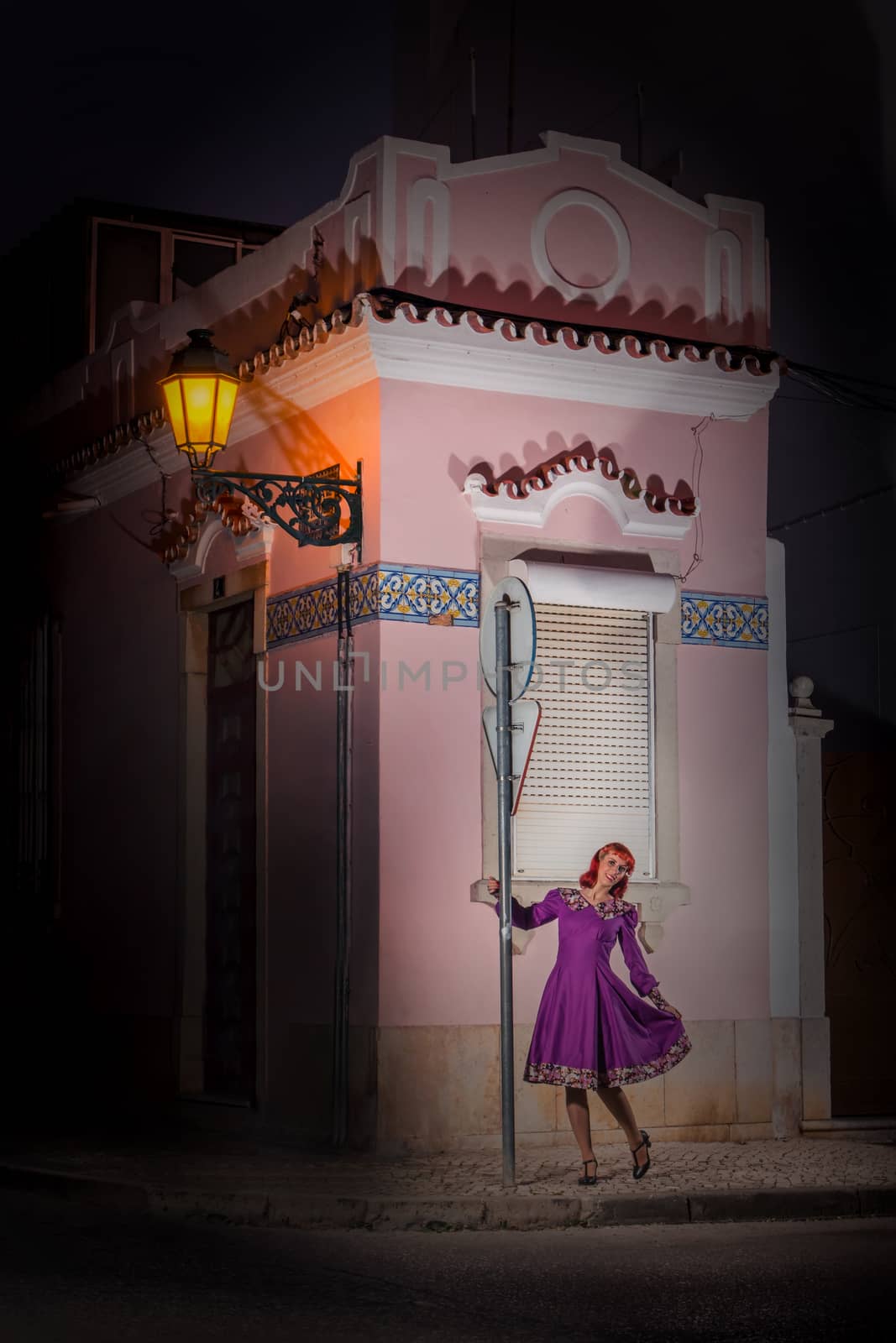 Close up view of a young redhead girl on a retro vintage dress on the urban city.