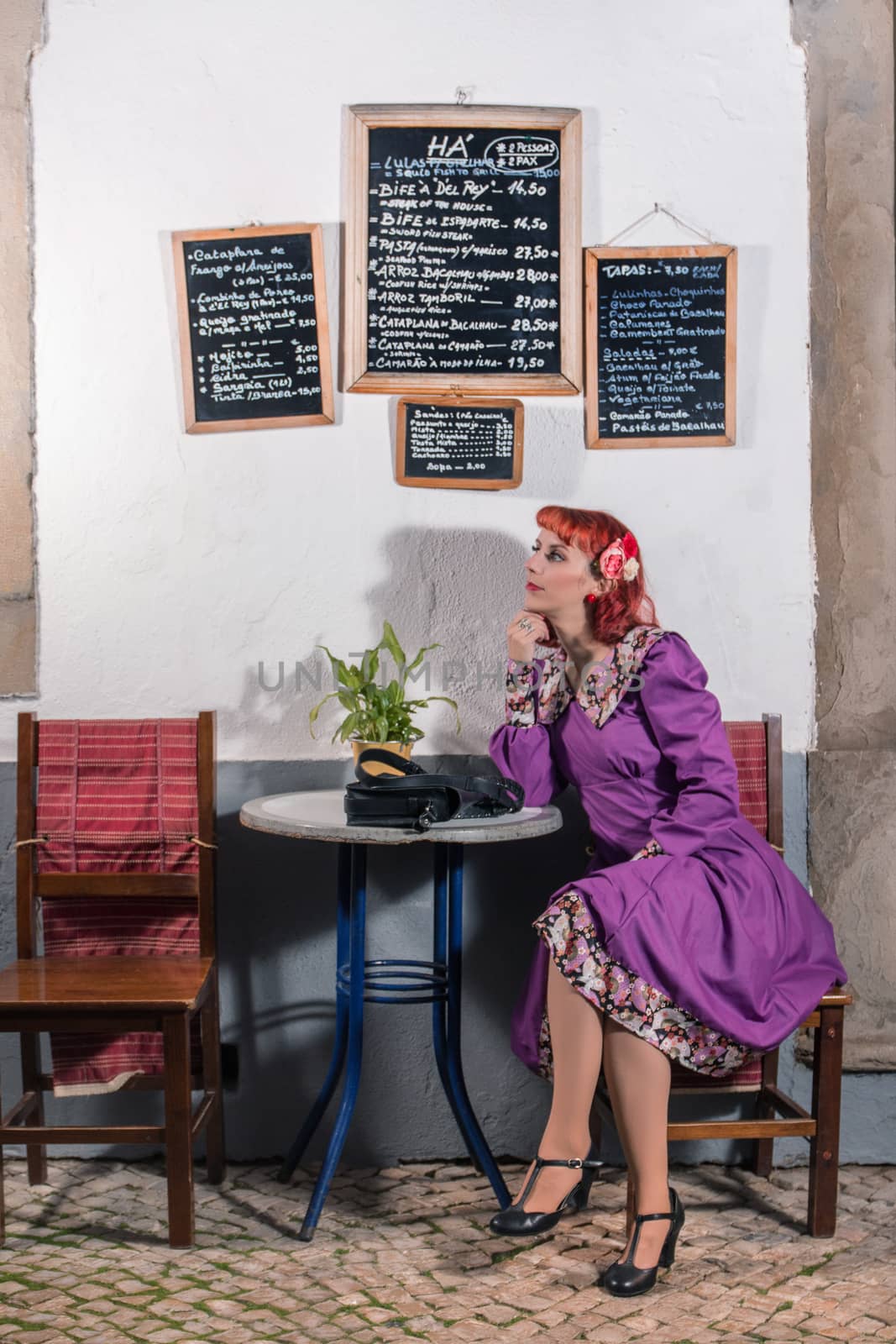 Close up view of a young redhead girl on a retro vintage dress on the urban city.