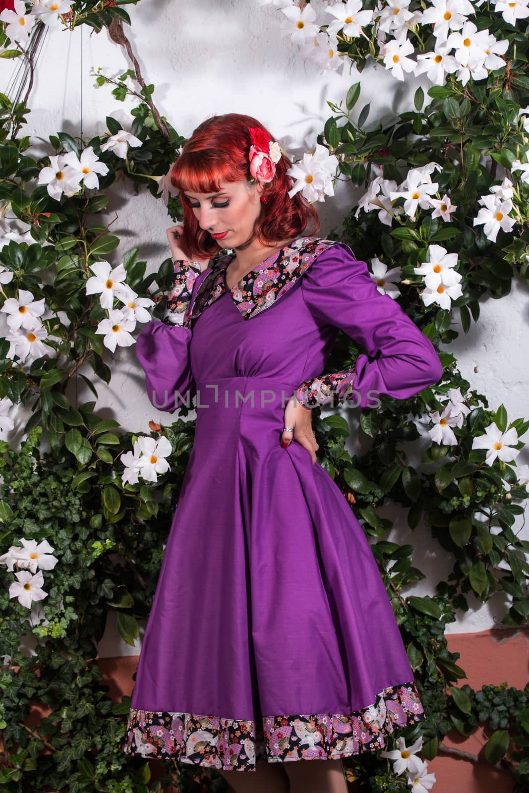 Close up view of a young redhead girl on a retro vintage dress on the urban city.