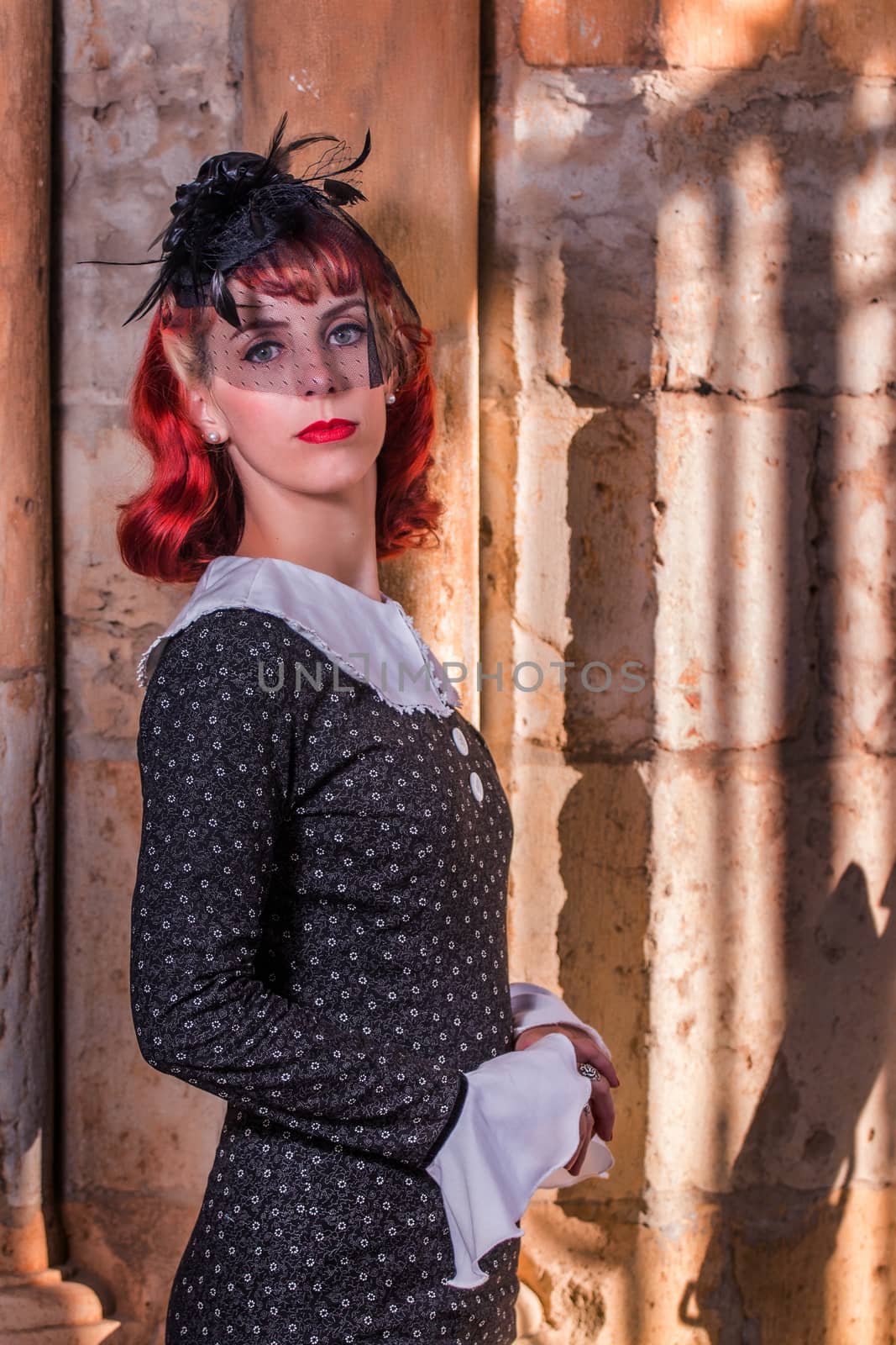 Close up view of a young redhead girl on a retro vintage dress on the urban city.