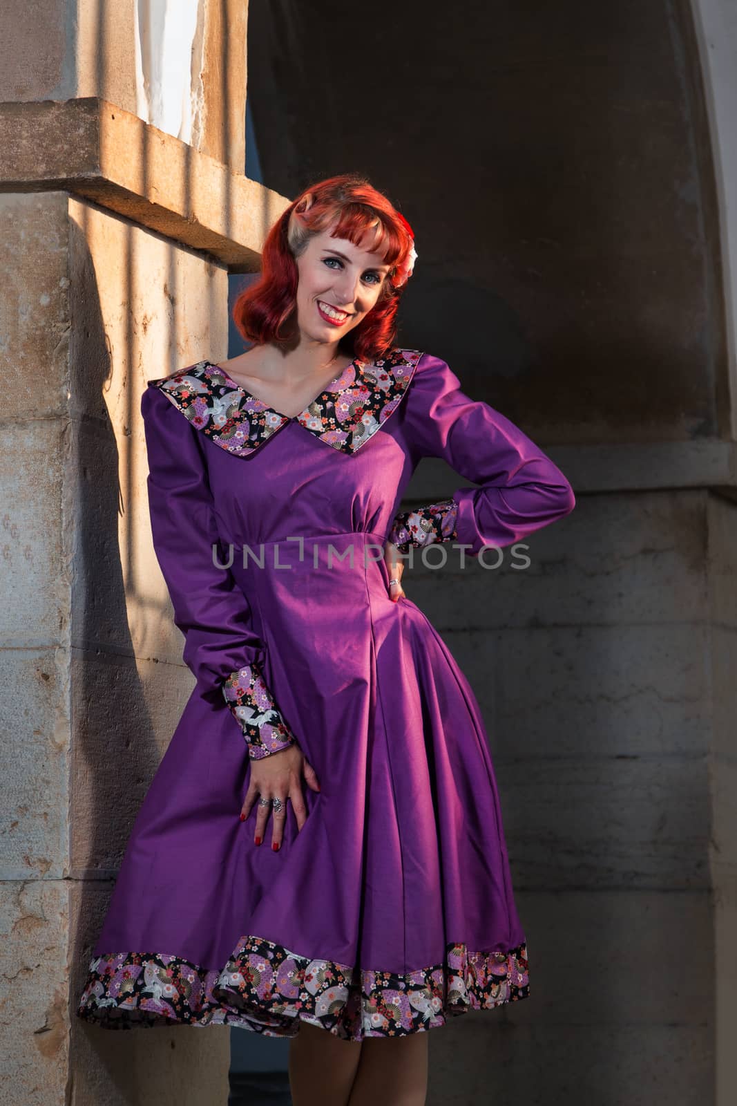 Close up view of a young redhead girl on a retro vintage dress on the urban city.