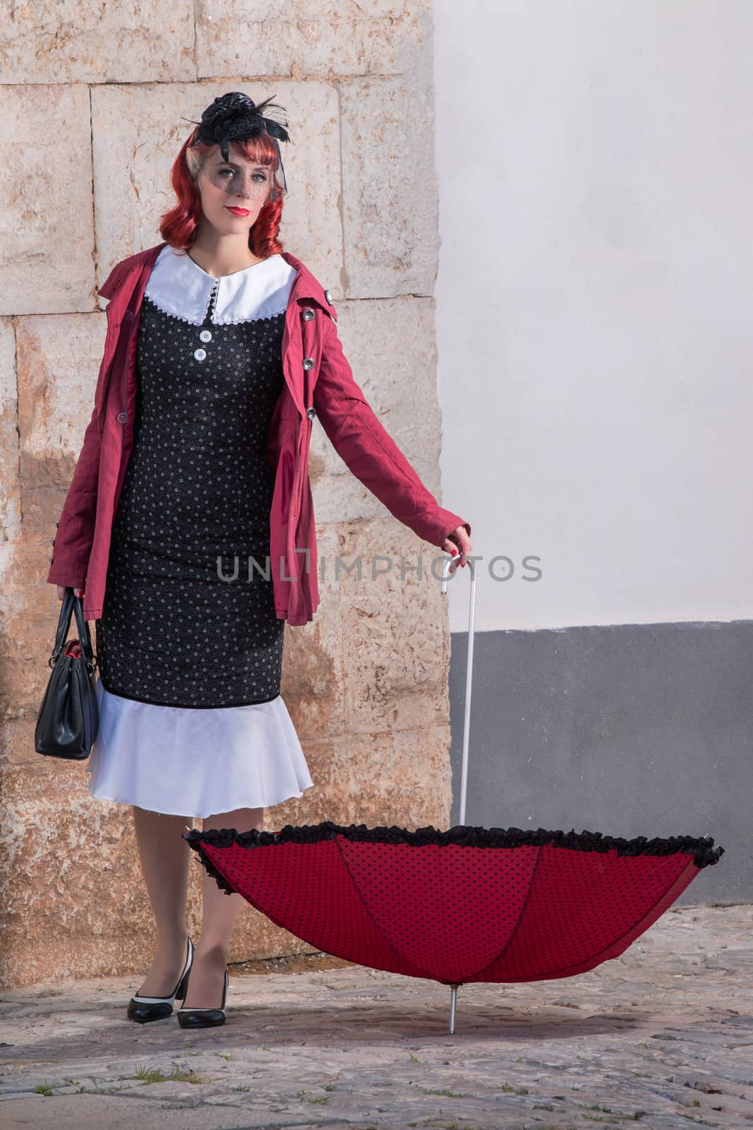 Close up view of a young redhead girl on a retro vintage dress on the urban city.