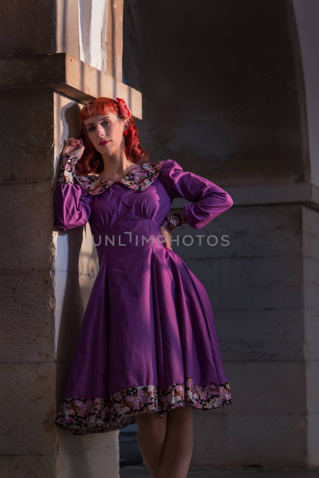 Close up view of a young redhead girl on a retro vintage dress on the urban city.