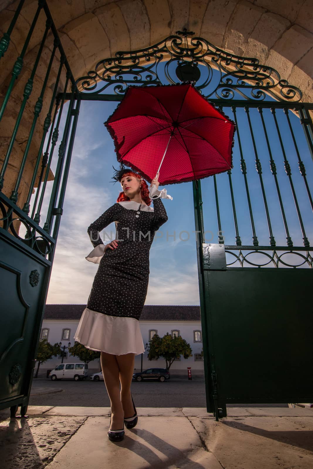 Close up view of a young redhead girl on a retro vintage dress on the urban city.