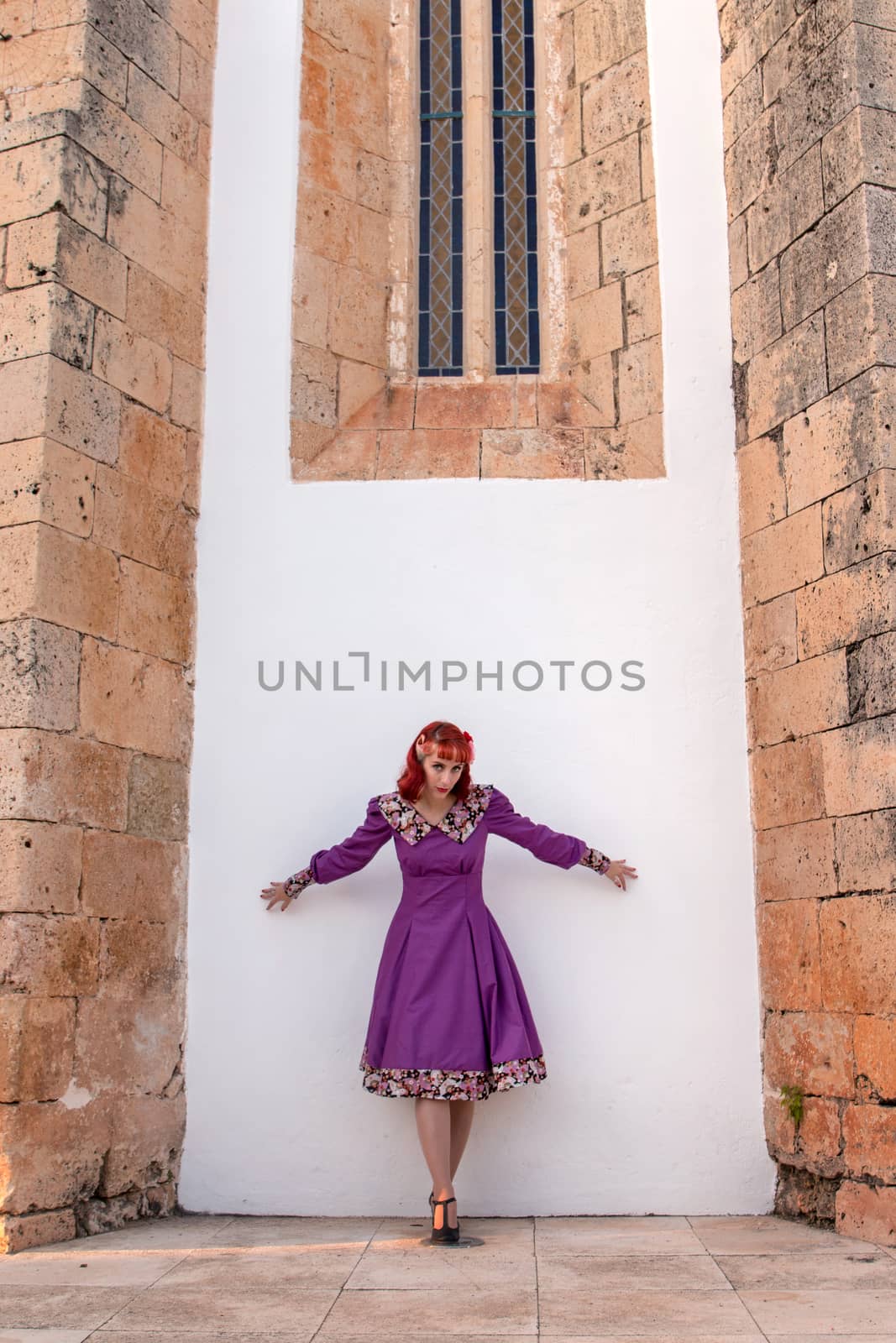 Close up view of a young redhead girl on a retro vintage dress on the urban city.